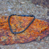 Black rope chain bracelet on rock
