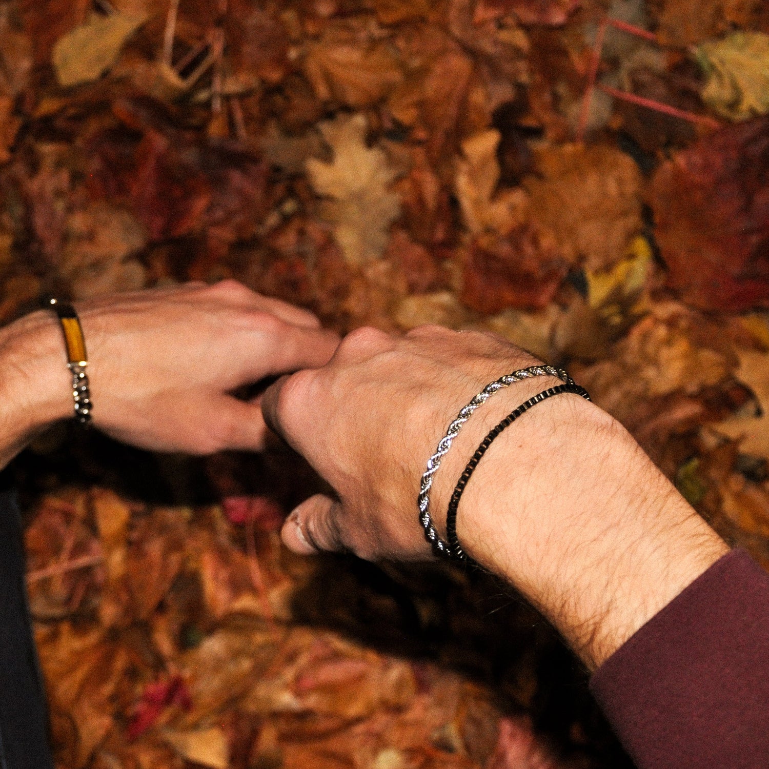 Man with leaves in jeans wearing silver rope chain bracelet