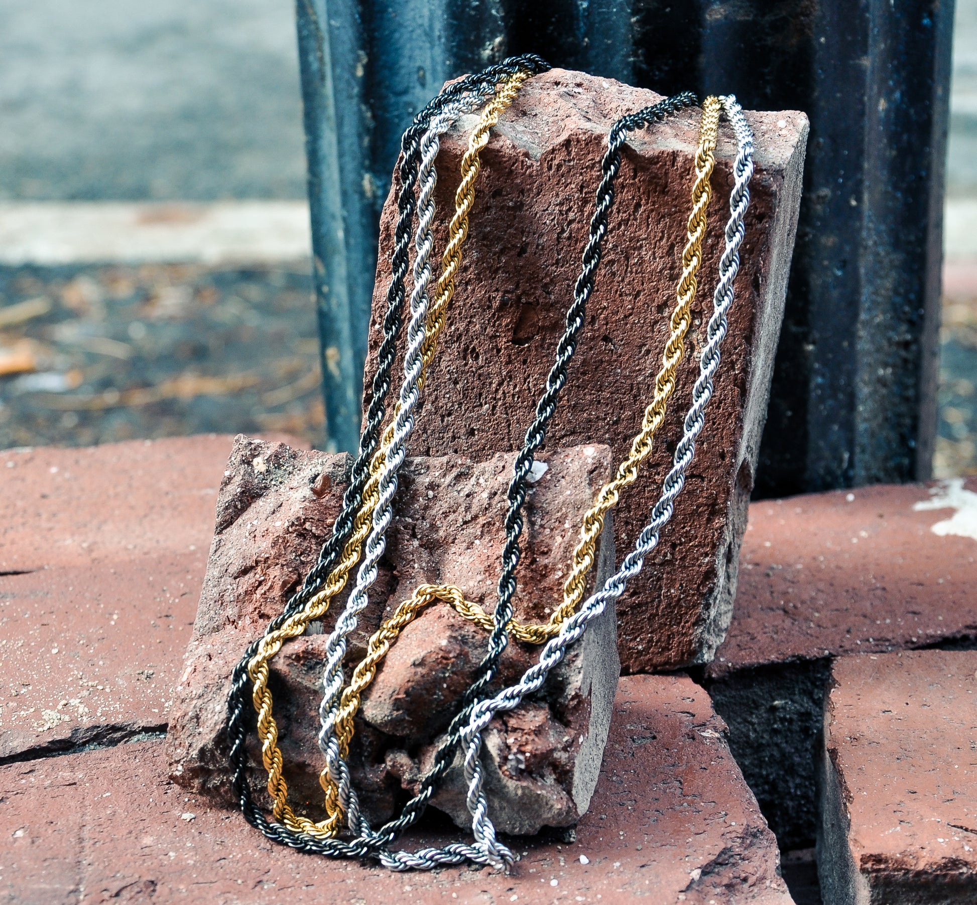 rope chain necklaces hanging on brick 